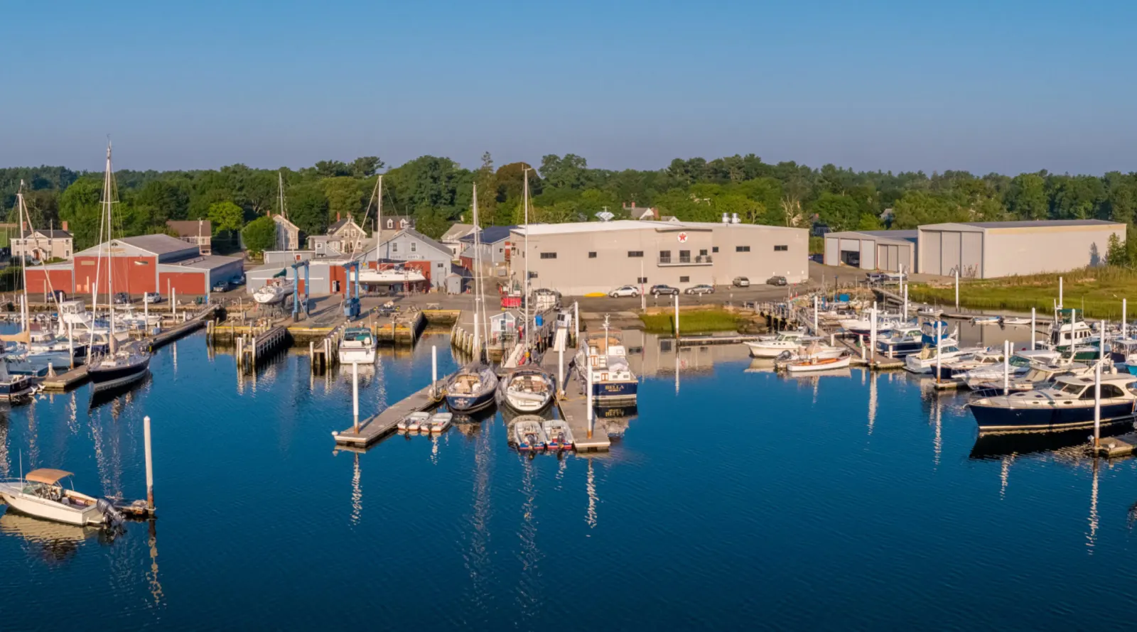 Aerial view of the Burr Brothers Boats yard, docks and sheds on Sippican Harbor in Marion, Massachusetts